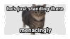 picture of tabby cat on stamp with text 'he's just standing there menacingly